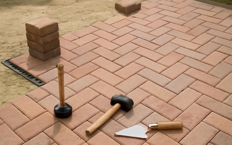 AI concept: Crew laying pavers in a herringbone pattern