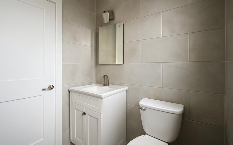 Large porcelain tile set on a small bathroom wall