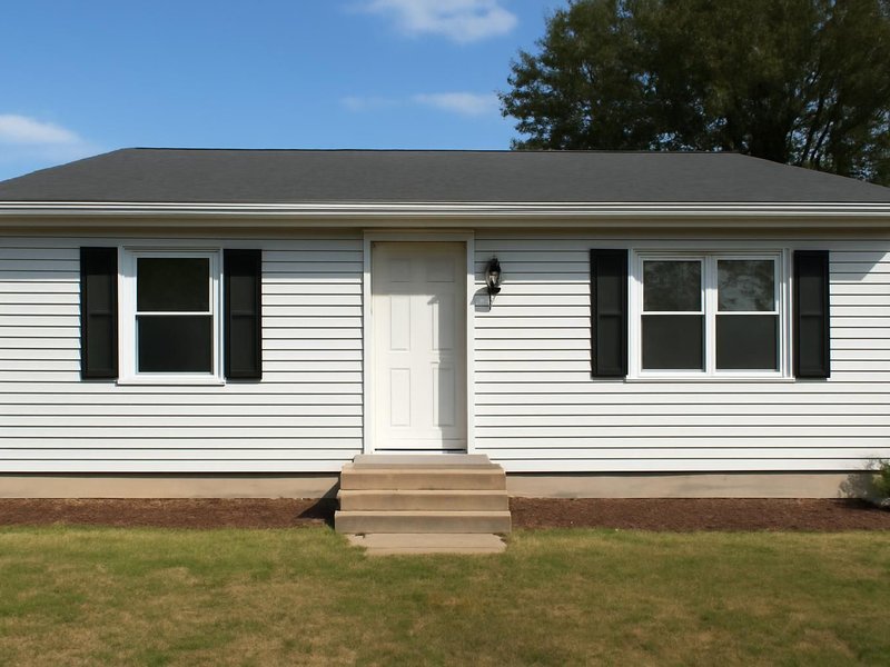 AI concept: Existing condition: ranch house with dented white aluminum siding