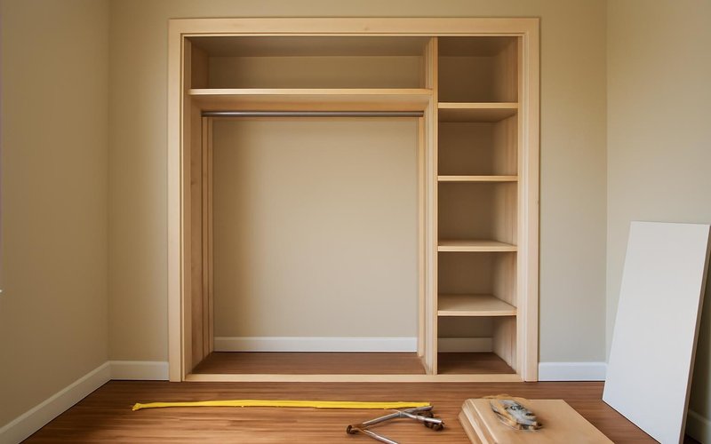 Supervisor measuring a bedroom wall for a new closet